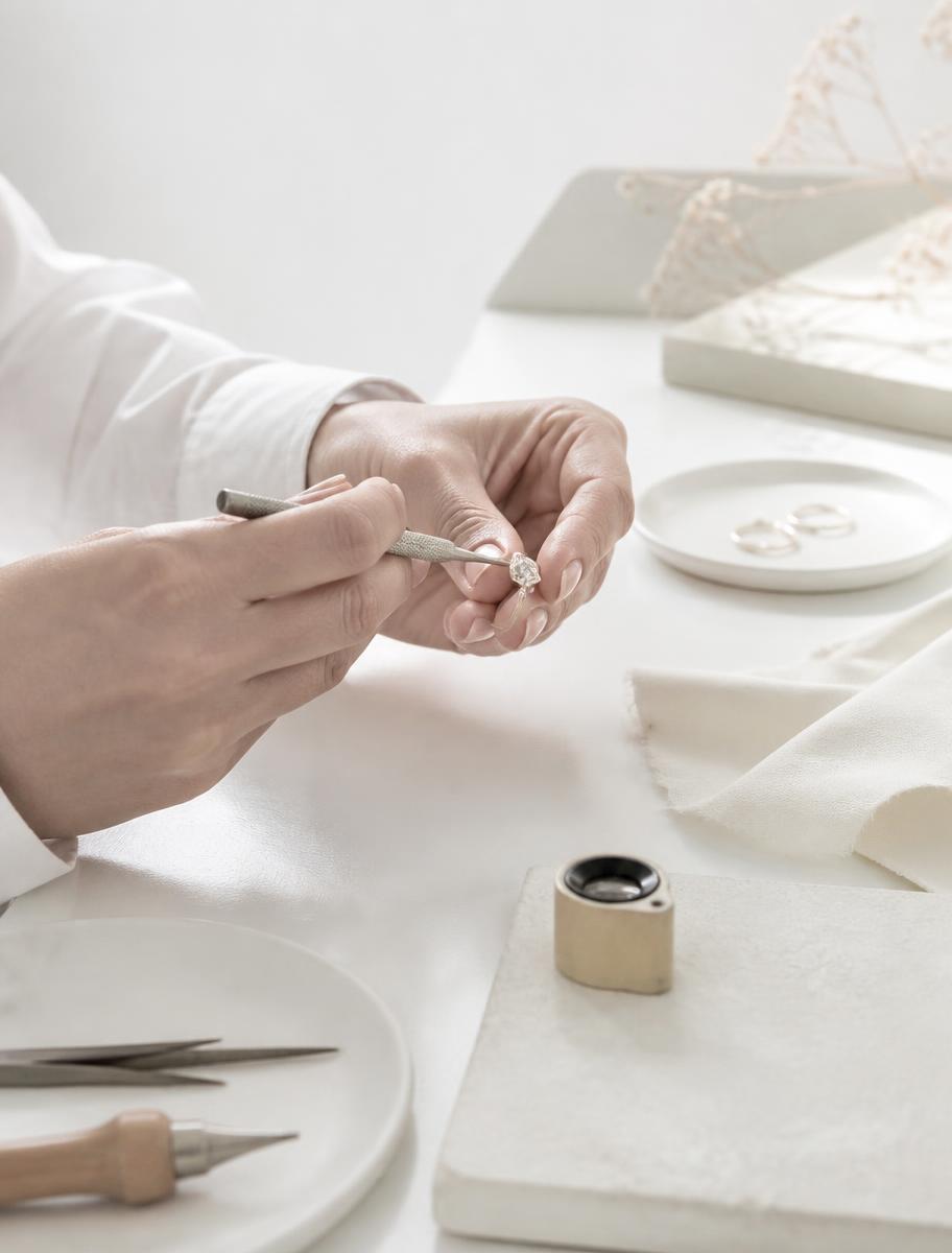 A jeweller setting a diamond by hand at the bench