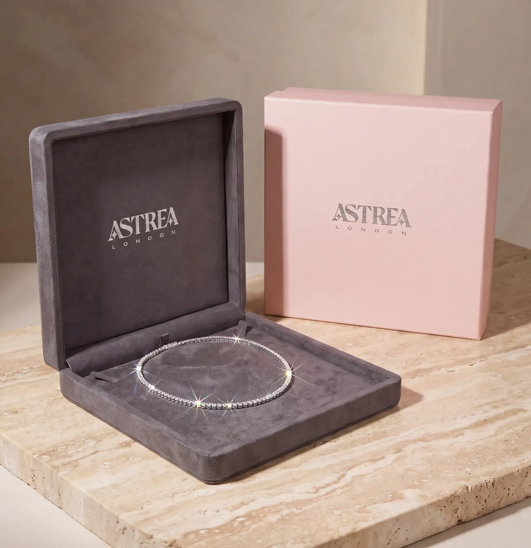 Astrea London necklace packaging — flat suede case and pink outer box